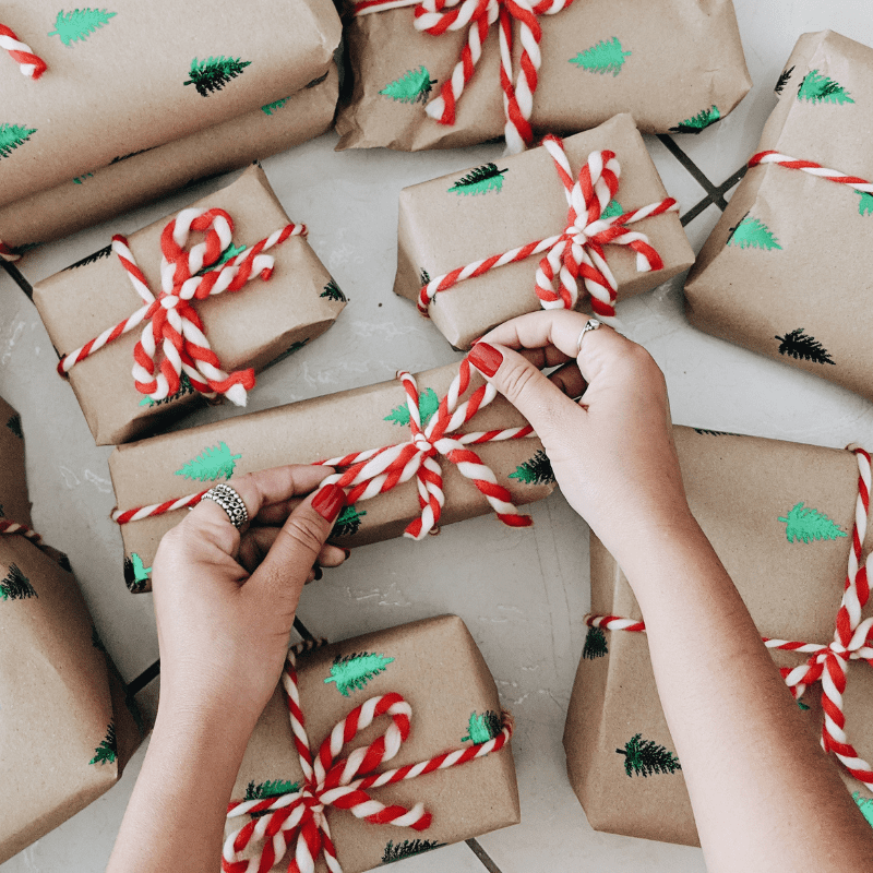 A business owner preparing small holiday gifts for their customers.