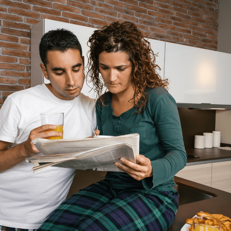 couple reading a printed newspaper article