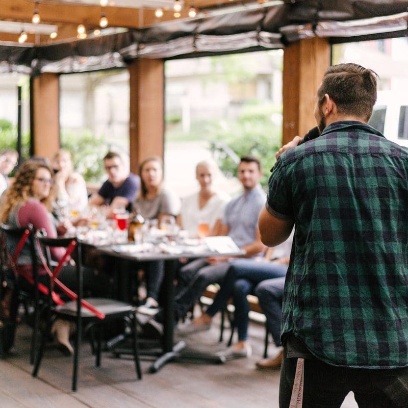 owner speaking to staff at holiday party