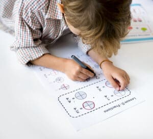 Kid Concentrating with Mathematics Homework Learning child concentrating on a custom worksheet in school