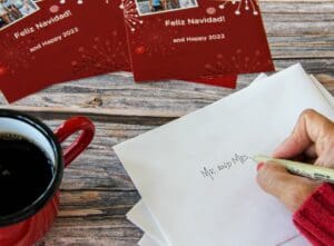 woman-addressing-christmas-cards-envelopes-to-be-s-2023-11-27-05-02-33-utc writing reciever information on back of envelop, mr and mrs.