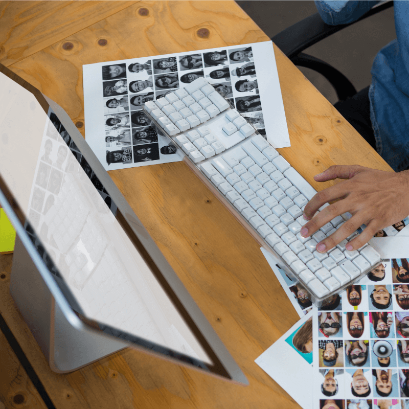 man-with-photographs-working-on-imac photographer working on desktop