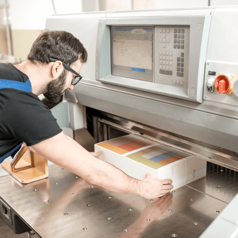 man-working-with-cutting-machine-at-the-printing-press worker at the cutting machine in a printing shop