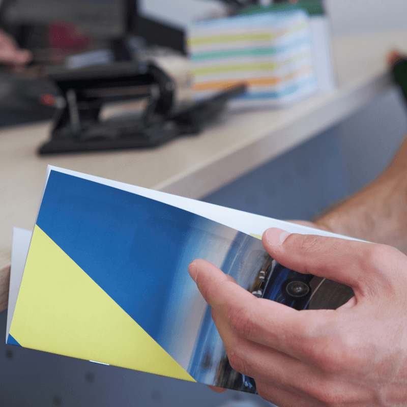 a-man-rents-a-car holding brochure up close of man holding business brochure