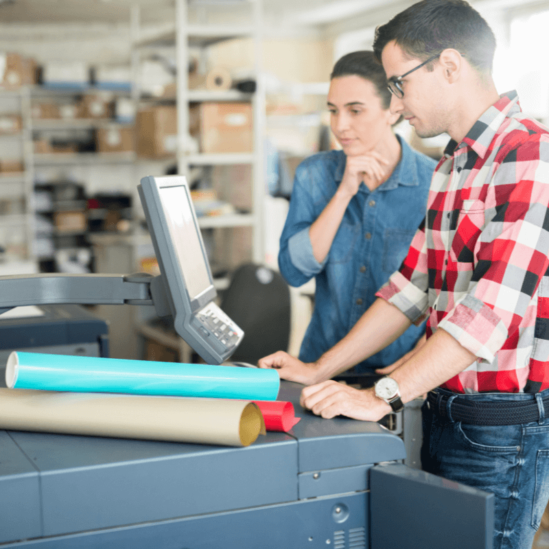 coworking-man-and-woman-using-printer coworkers using a professional printer in print shop for seasonal print marketing materials
