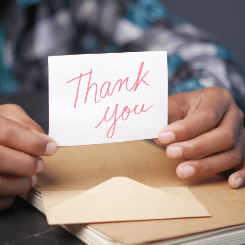 close up of man hand reading a thank you card