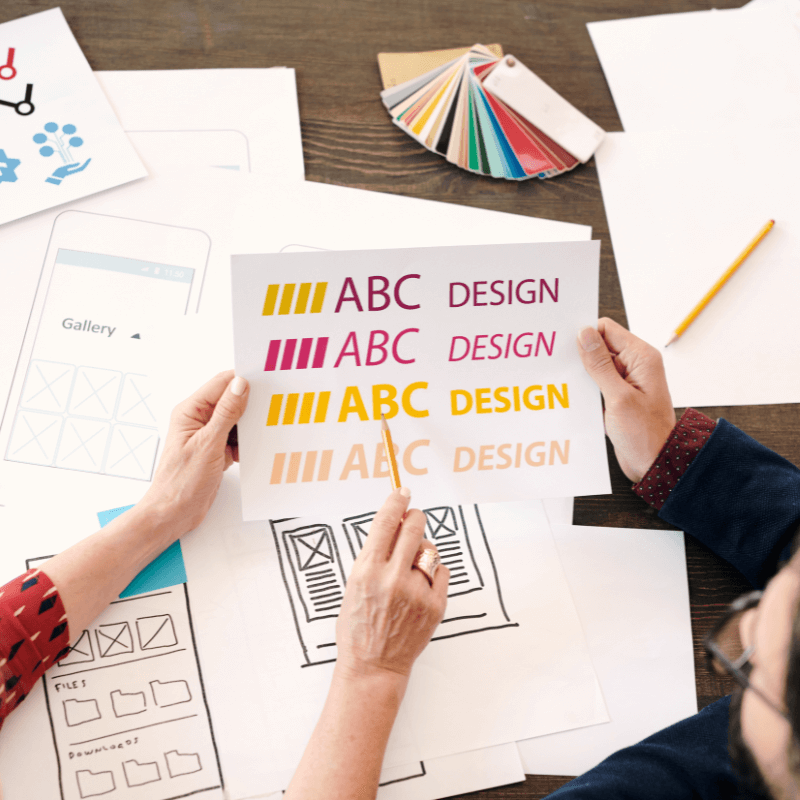 Above point of view of graphic designers discussing logo fonts and colors