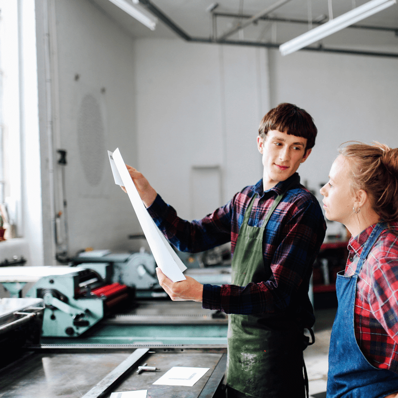 smiling lady viewing information on monitor in print shop
