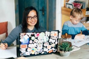 Woman working on her laptop, which is covered in custom brand stickers.