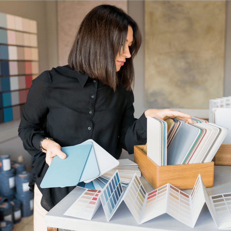 woman-choosing-paint-colors-in-modern-interior-design Business owner comparing printed marketing material options