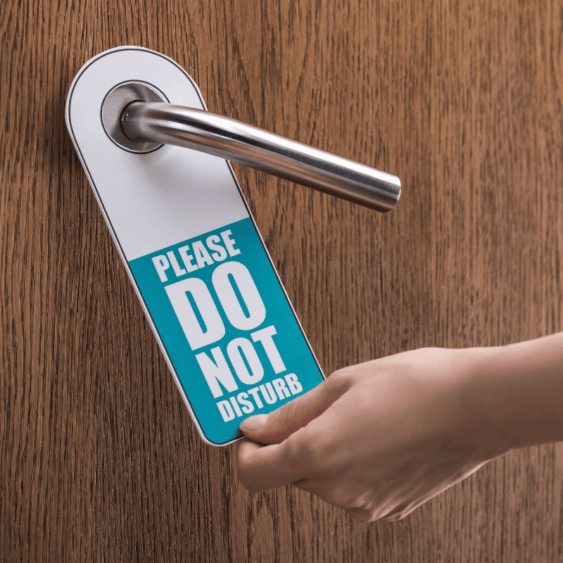 Close-up of woman’s hand placing a door hanger on a door handle