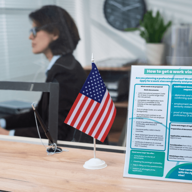 woman working at visa center with flyer on desk front and center